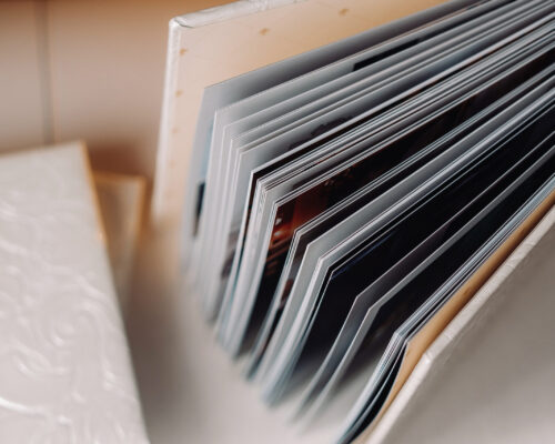 Composition of photo books in genuine white leather . Fragment of a photobook binding.